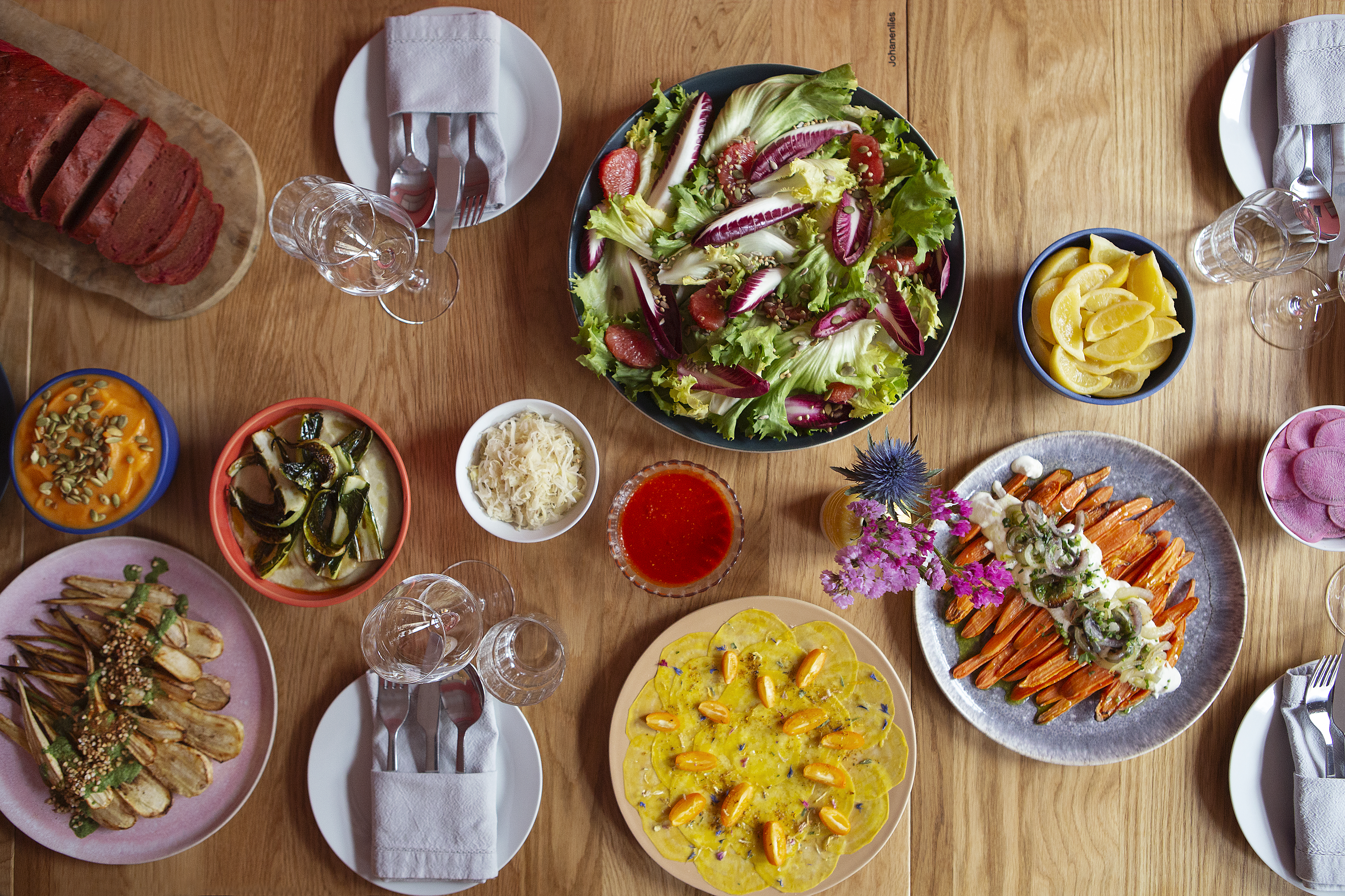 Holztisch mit runden Tellern mit farbenfrohem Essen