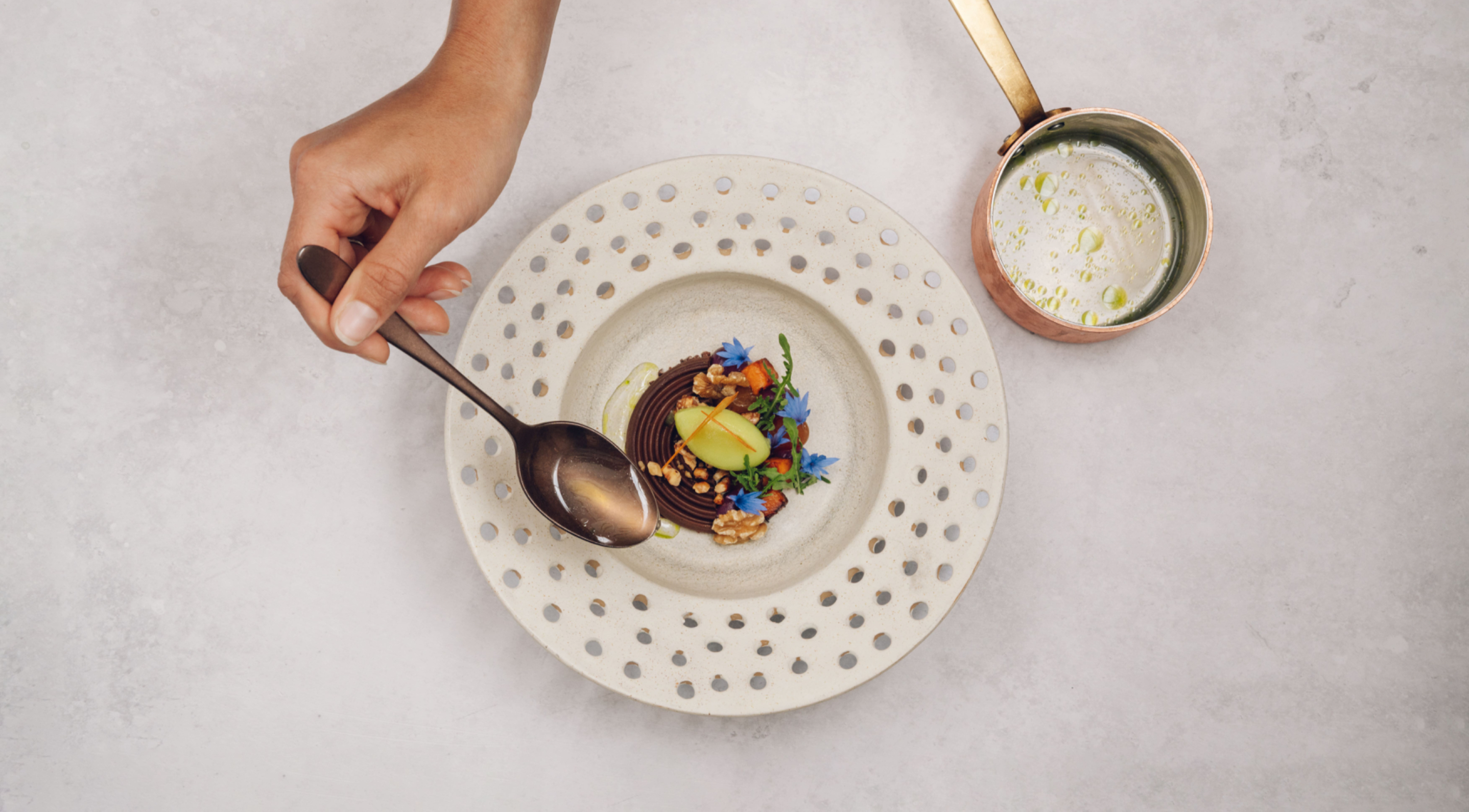 Hand ergänzt Sauce auf weissen Teller mit Essen darauf
